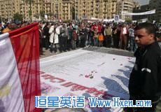 Mourners throw roses and pray over the names of some of those killed in Egypt's revolution, at a makeshift memorial in Tahrir Square, Cairo, February 12, 2011