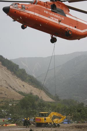 An excavator is carried to the barrier lake in Tangjiashan, Beichuan County, southwest China's Sichuan Province, May 26, 2008. A Mig-26 helicopter has carried machinery from Leigu to Tangjiashan by air and the operation on dynamiting the dam of the barrier lake is speeded up.